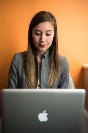 woman in gray suit uses apple macbook for business 600 optimized